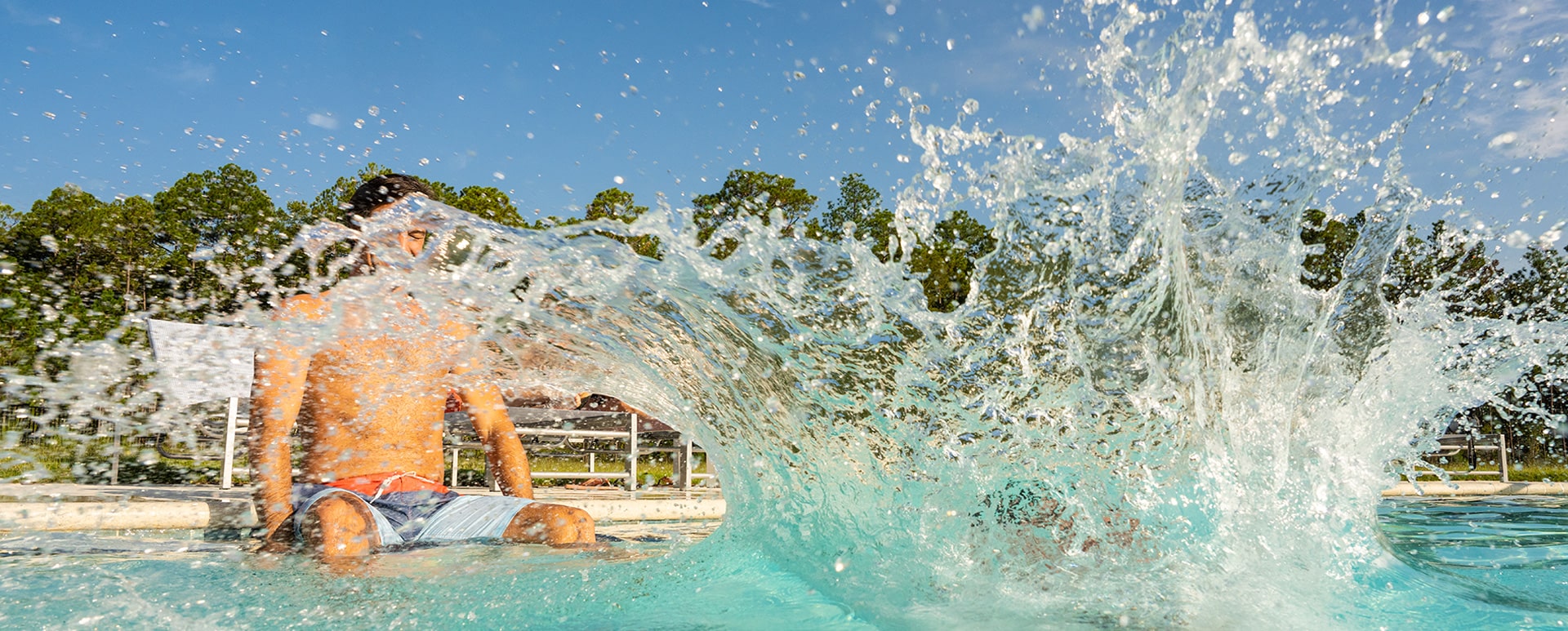 kid jumping in pool at an amenity center