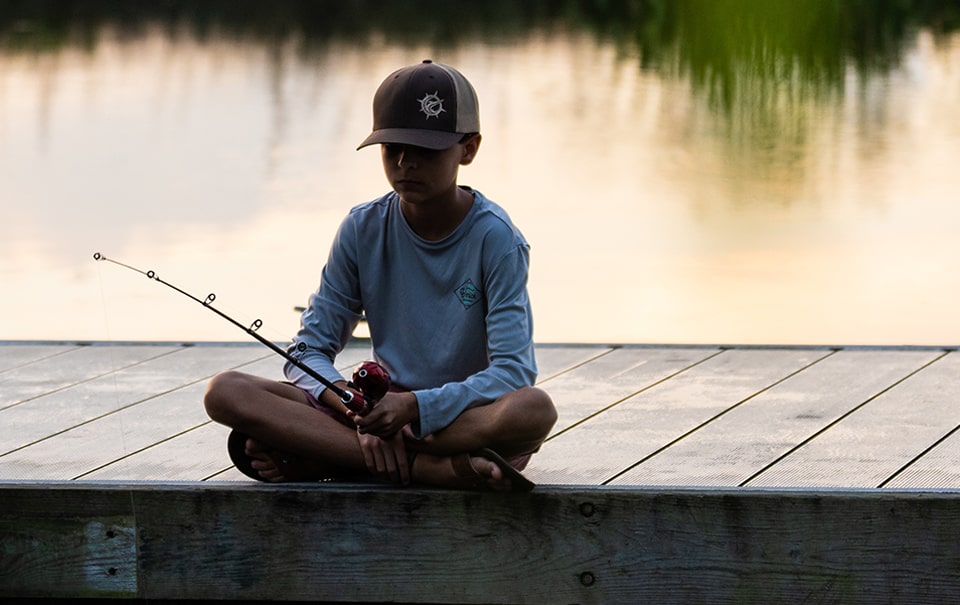 boy fishing at river near wylder