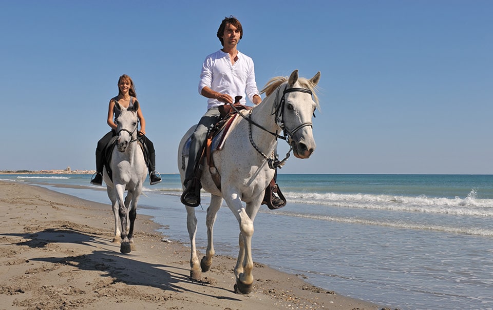 couple riding horse on the beach in fort pierce florida