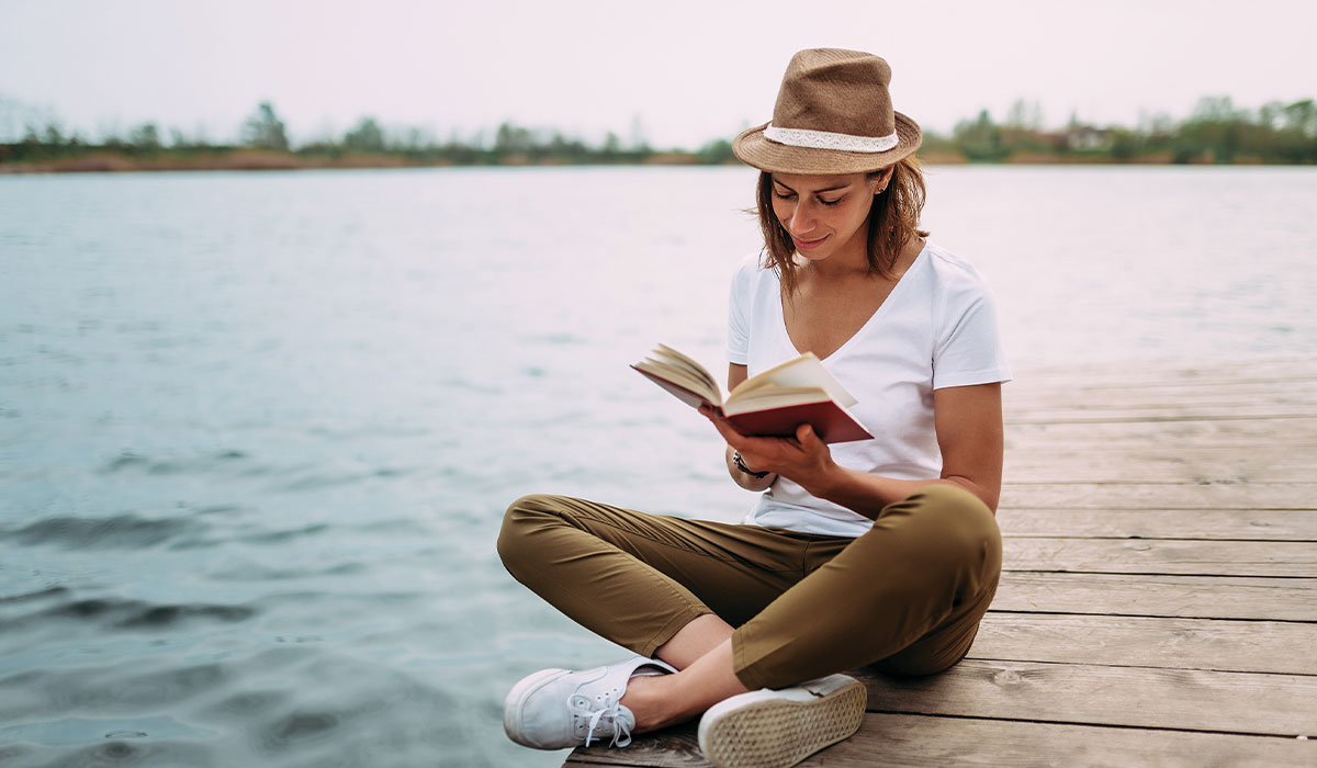 Florida Resident reading on a dock at a lake