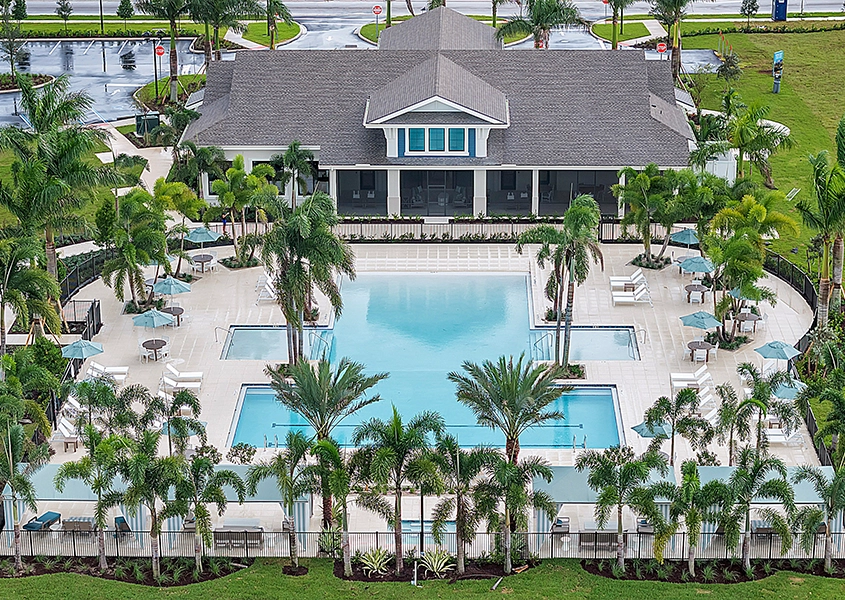 Resort-Style Pool and Clubhouse at Wylder Port St. Lucie Resort-style pool and clubhouse surrounded by palm trees at Wylder Port St. Lucie