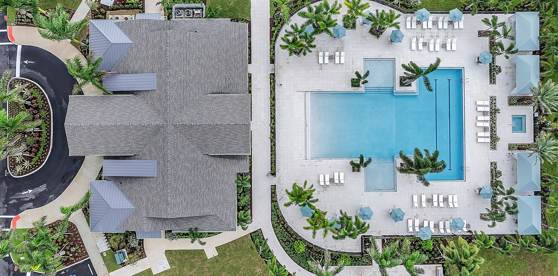 Aerial view of Wylder Port St. Lucie clubhouse and resort-style pool surrounded by palm trees