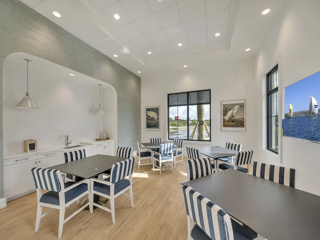 Café and card room with striped seating at Wylder Port St. Lucie clubhouse