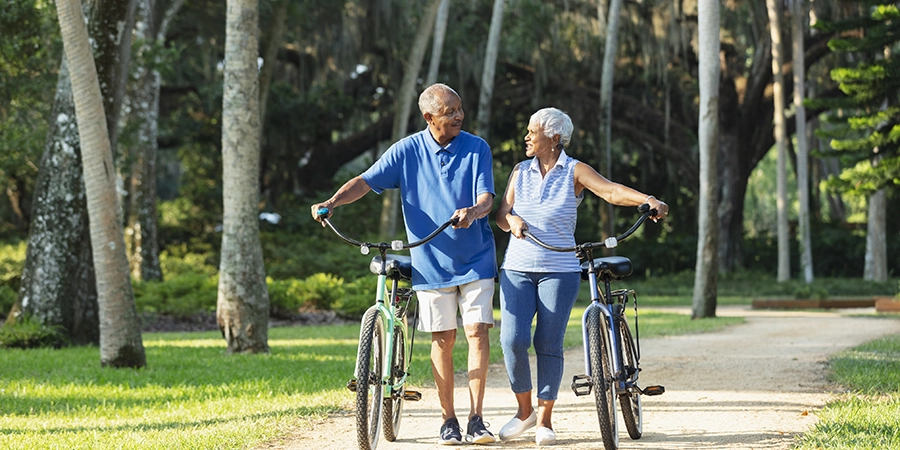 wylder mature couple walking bikes in the community