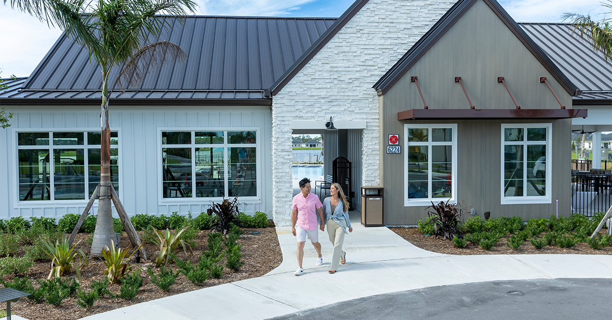 Couple walks hand in hand toward a modern community amenity building.