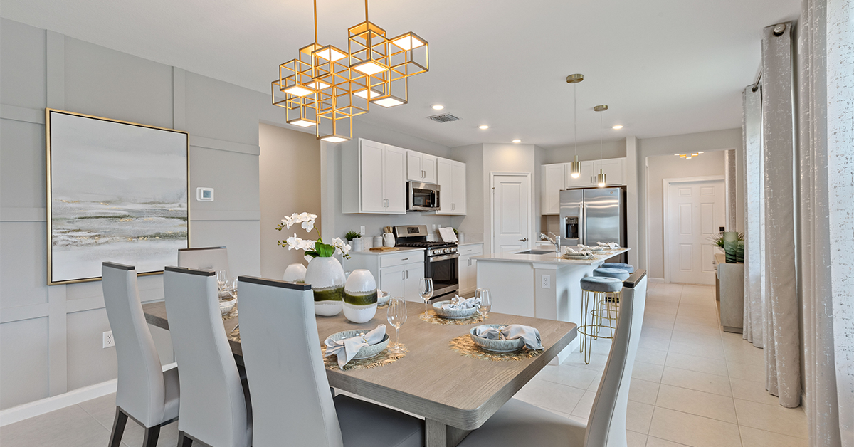 Open kitchen and dining area with island, bar stools, and modern lighting.