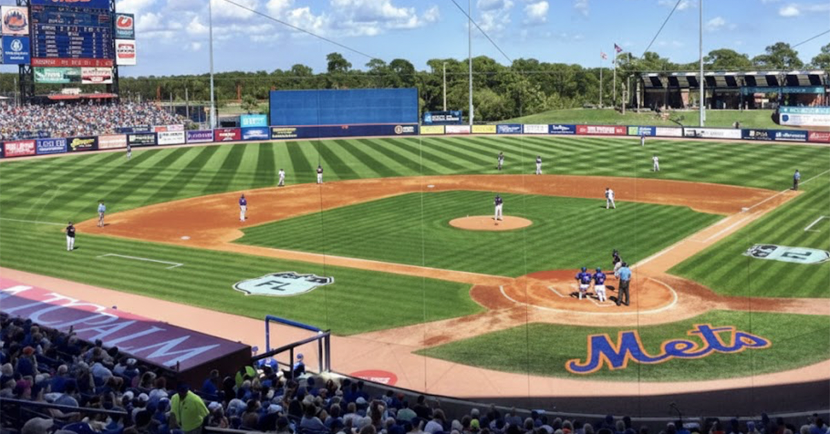Baseball game at stadium with crowd and scoreboard.