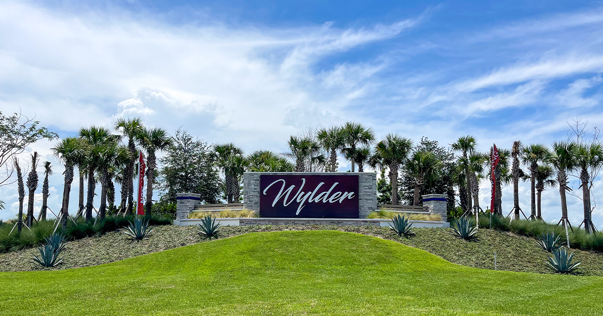 Wylder community entrance monument sign with palm trees and landscaping