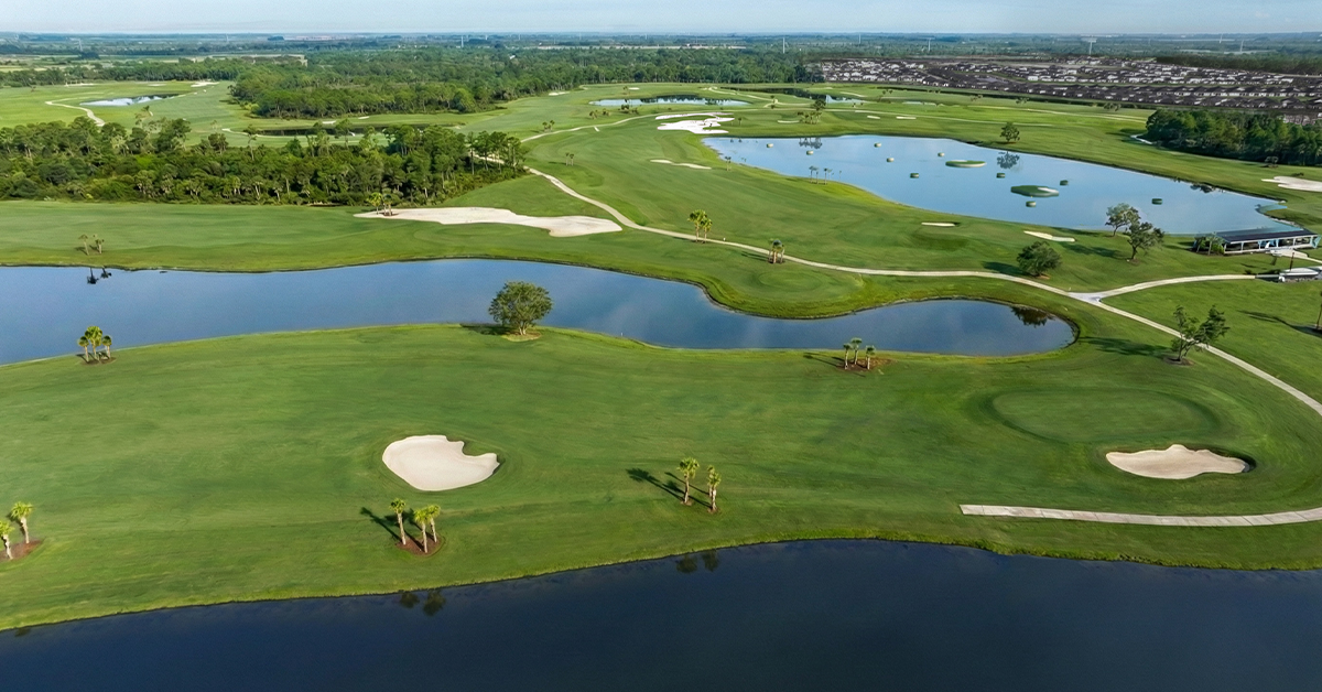 Aerial view of golf course with fairways, sand bunkers, and lakes