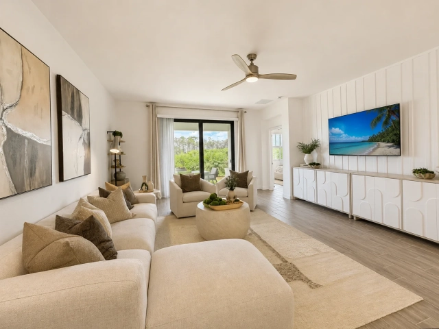 Family room with a cream sectional sofa, abstract wall art, and a wall-mounted TV above a white media console.